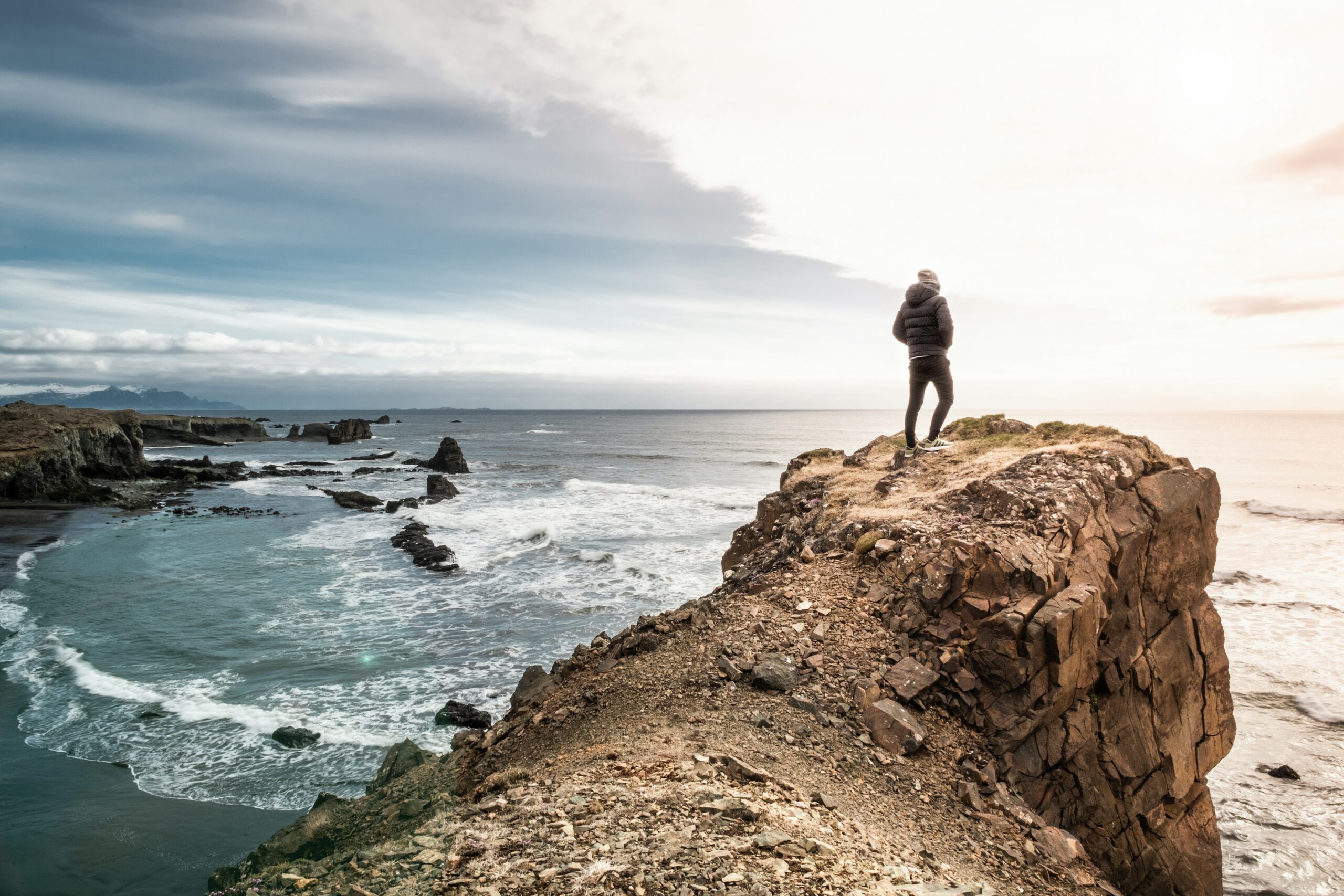 Person looking towards the horizine by the coast.